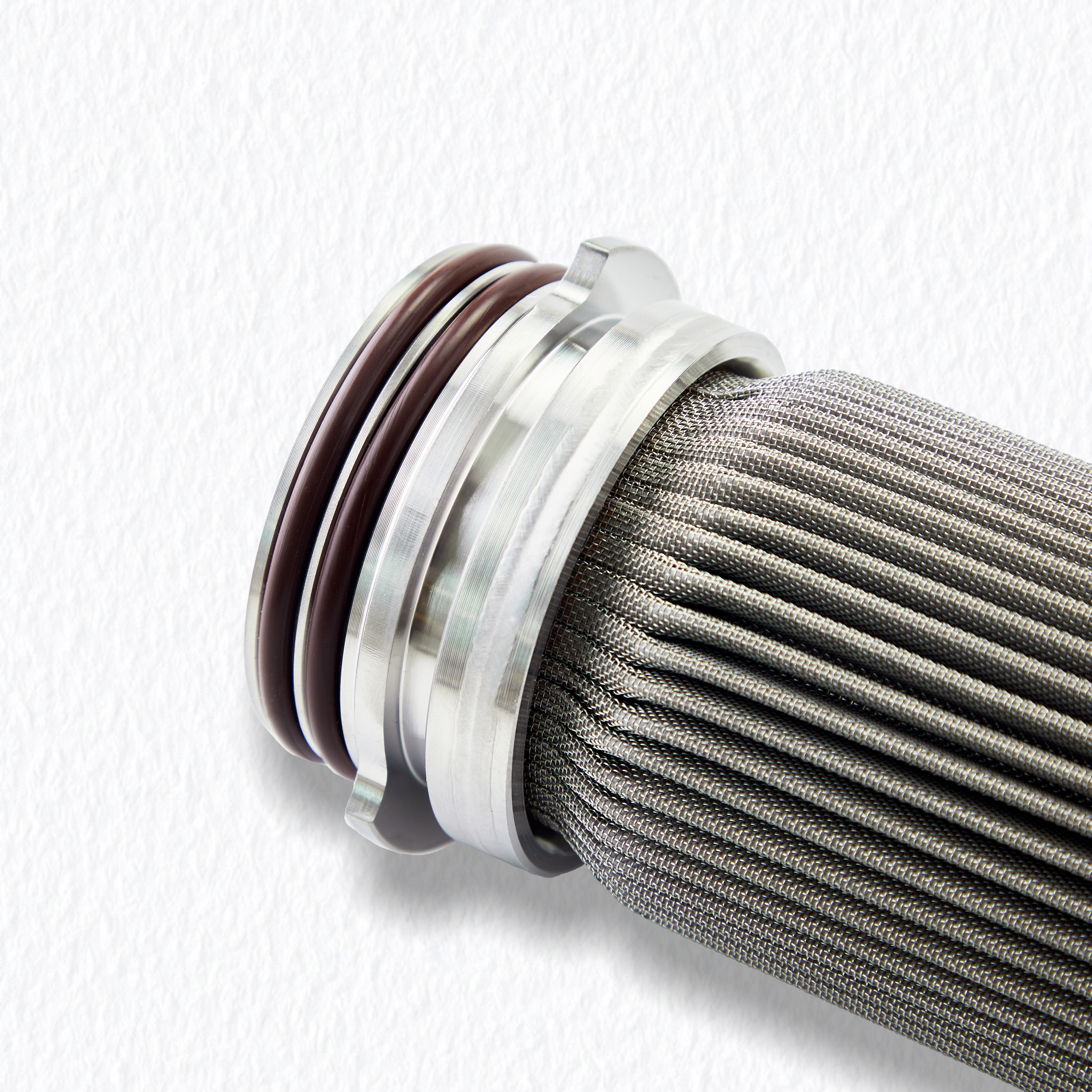 Detalhe de conex&atilde;o soldada do adaptador final em a&ccedil;o inoxid&aacute;vel e malha plissada, garantindo integridade estrutural sob alta press&atilde;o diferencial.